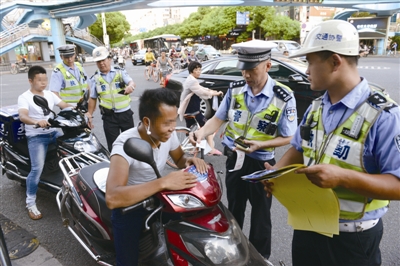 昨天下午，交警在市區(qū)城開天橋下管理電動車。蔣文廣 攝